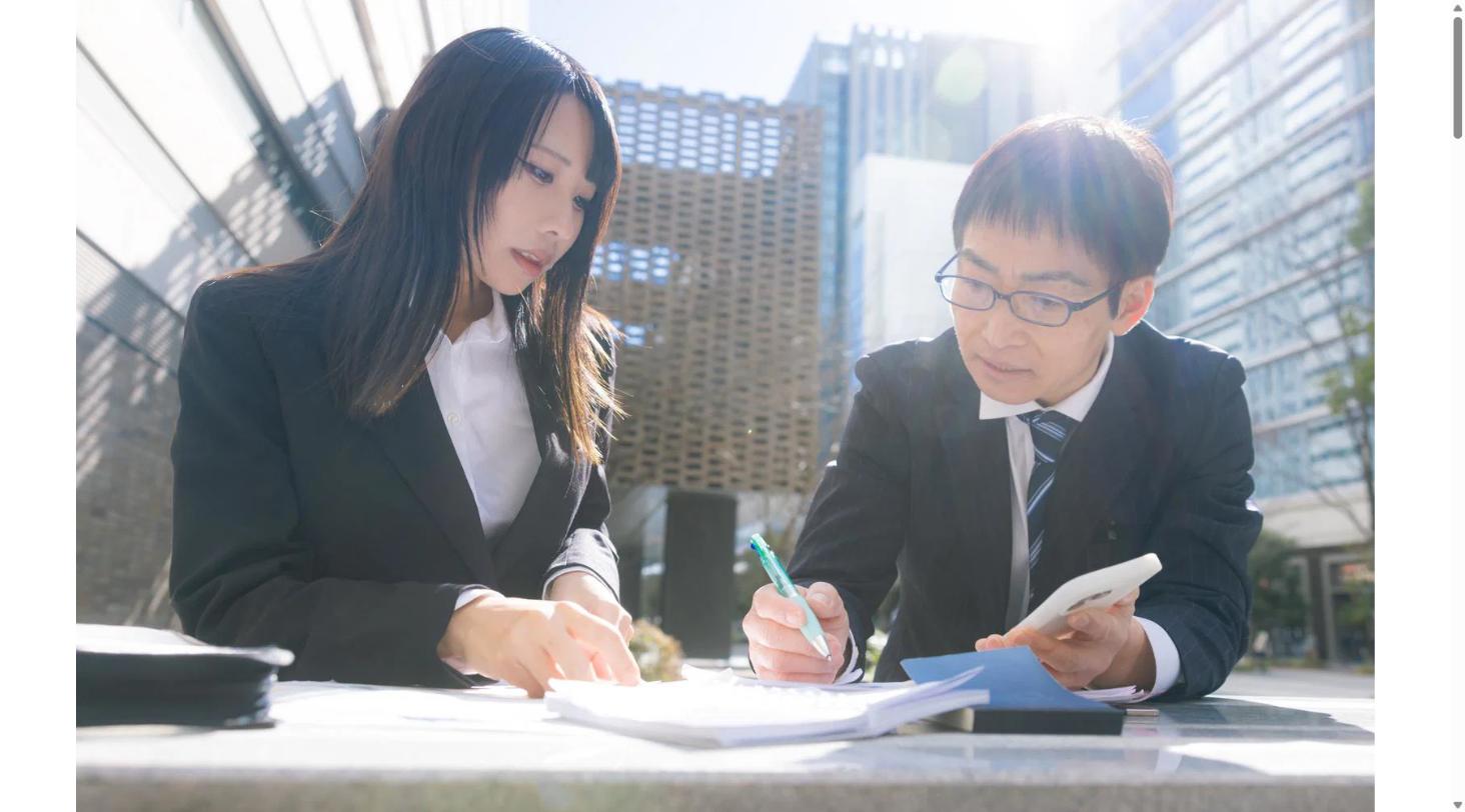 書類を確認しながら相談する男女のビジネスシーン