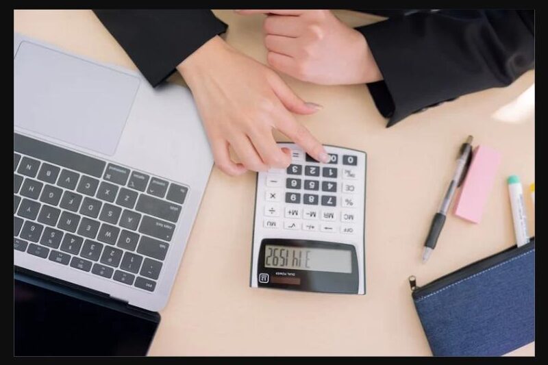 社会保険および労働保険の手続きを計算する女性の手元